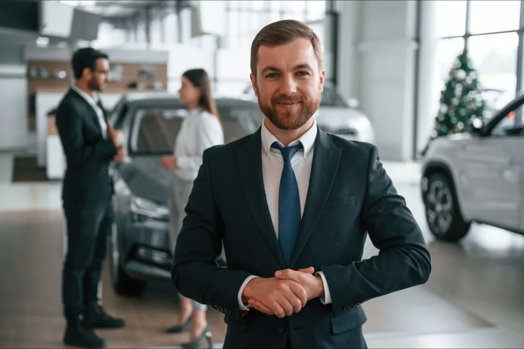 Man working in a car showroom smiling at the camera