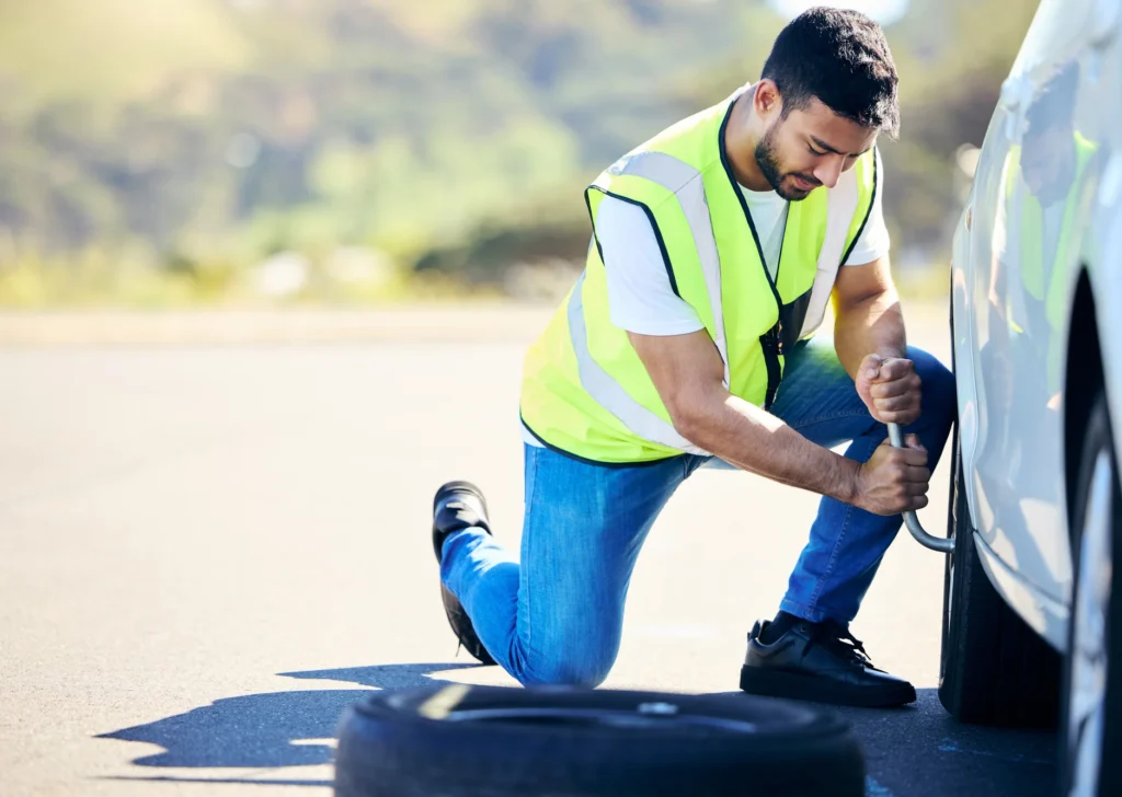 Mobile car repair person fixing a vehicle on the sde of the road