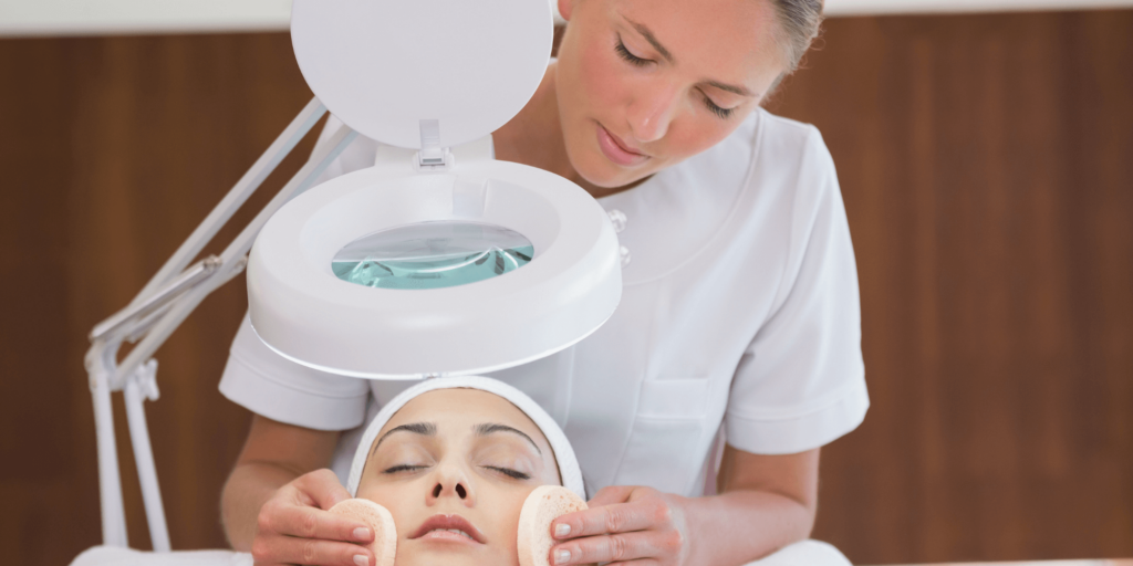 Beauty therapist applying facial treatment to a client in a salon setting.